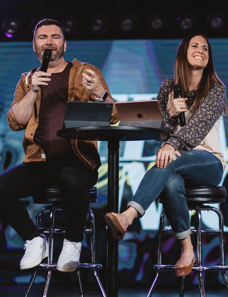Danny and Jamie Schulz speaking on stage at Sun City Church