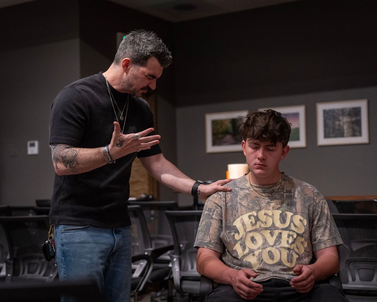A pastor praying with a student