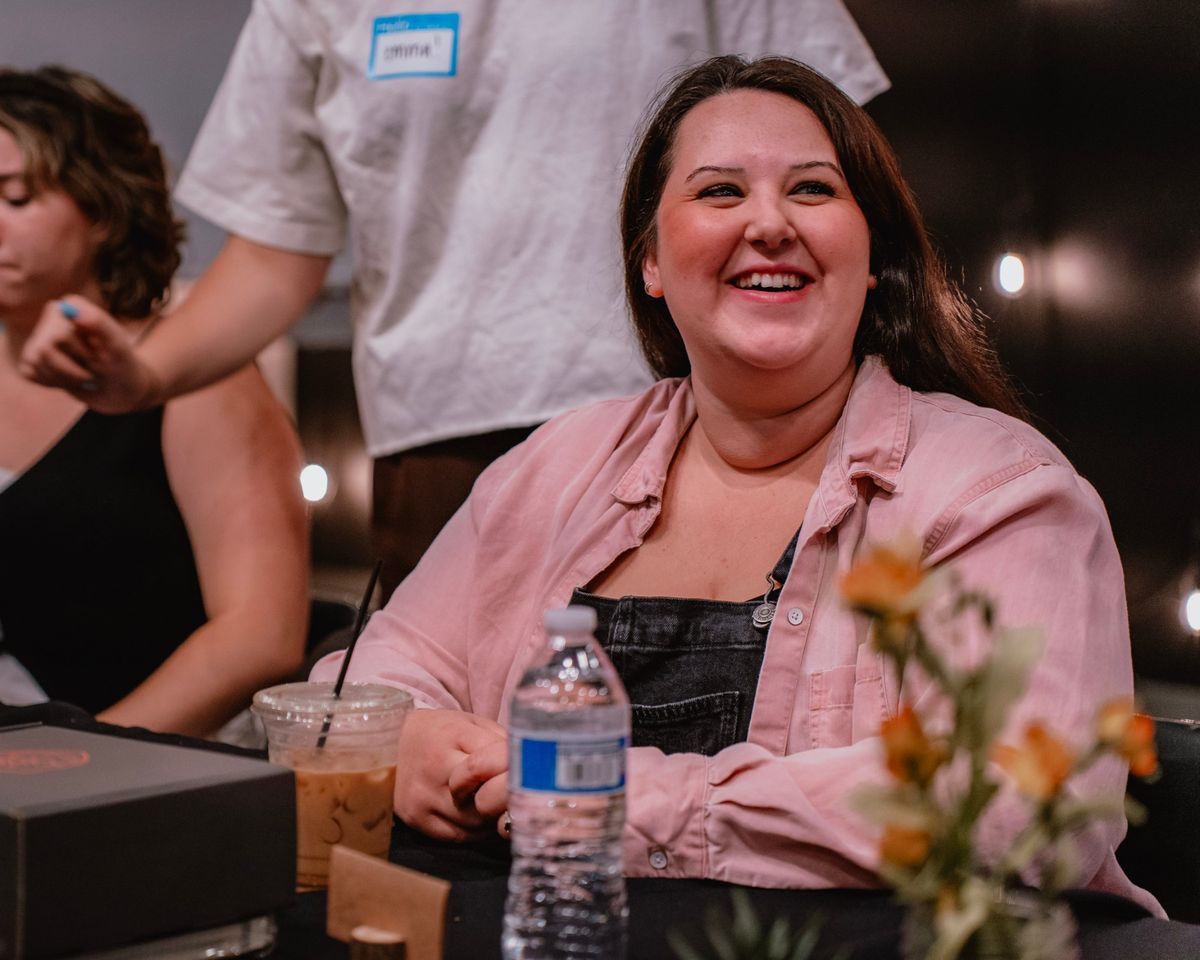 Guest laughing at a table during Preview Day